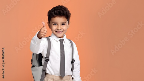 Portrait of a little caucasian boy laughing with thumbs up sign in studio