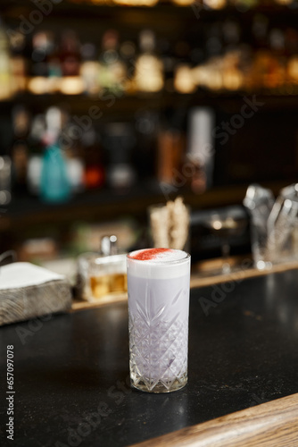 glass with classic milk punch flavored with cinnamon on bar counter, cocktail presentation