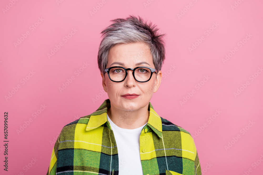Portrait of pleasant intellingent senior person with gray hairdo dressed plaid shirt look at camera isolated on pink color background