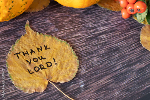 Thank You, LORD, handwritten quote on autumn leaf on wooden background with pumpkin and dry leaves. Gratitude, thanksgiving, praise to God Jesus Christ, Christian biblical concept. Close-up.