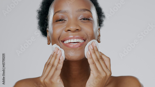 фотографія Woman, model and cotton pad on face with skincare, toner and happiness in advertisement, cosmetics and studio