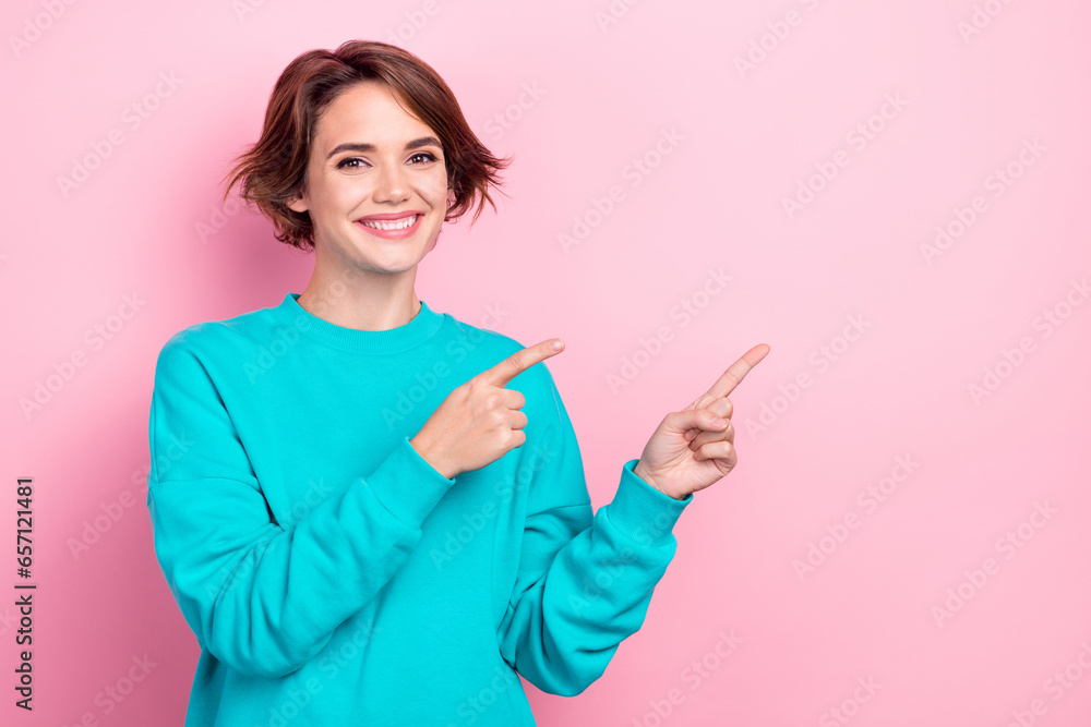 Photo of pretty lady indicating fingers empty space adv ads sale poster wear oversize pullover shirt isolated pink color background Photo of pretty lady indicating fingers empty space adv ads sale poster wear oversize pullover shirt isolated pink color background