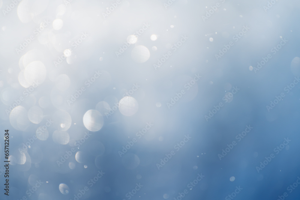 Blurred snowflakes in morning light in winter forest. Glowing bokeh abstract background.