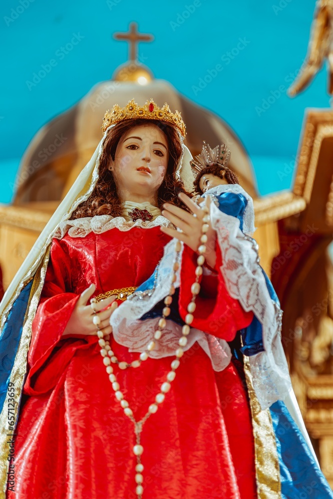 Obraz premium Statue of the Virgin of Rosario on an altar with church background