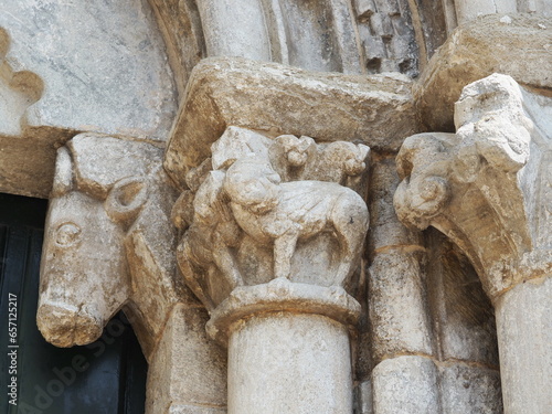 capitel con grifos afrontados, portalada de la iglesia de san pedro de portomarín, al fondo una cabeza de toro sobre el que se apoya el tímpano, lugo, galicia, españa, europa 