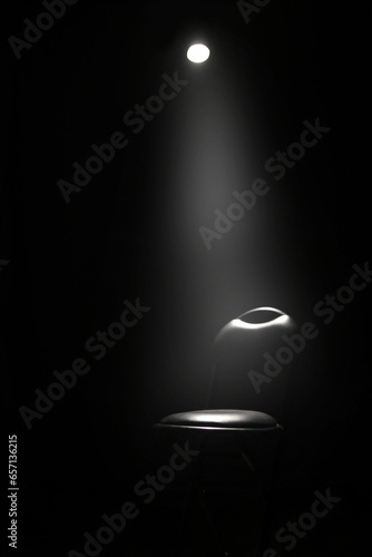  black chair on dark background, low key and spotlight.