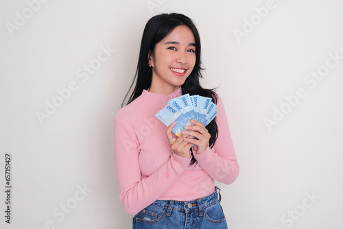 Asian young woman smiling happy while holding a lot of money photo