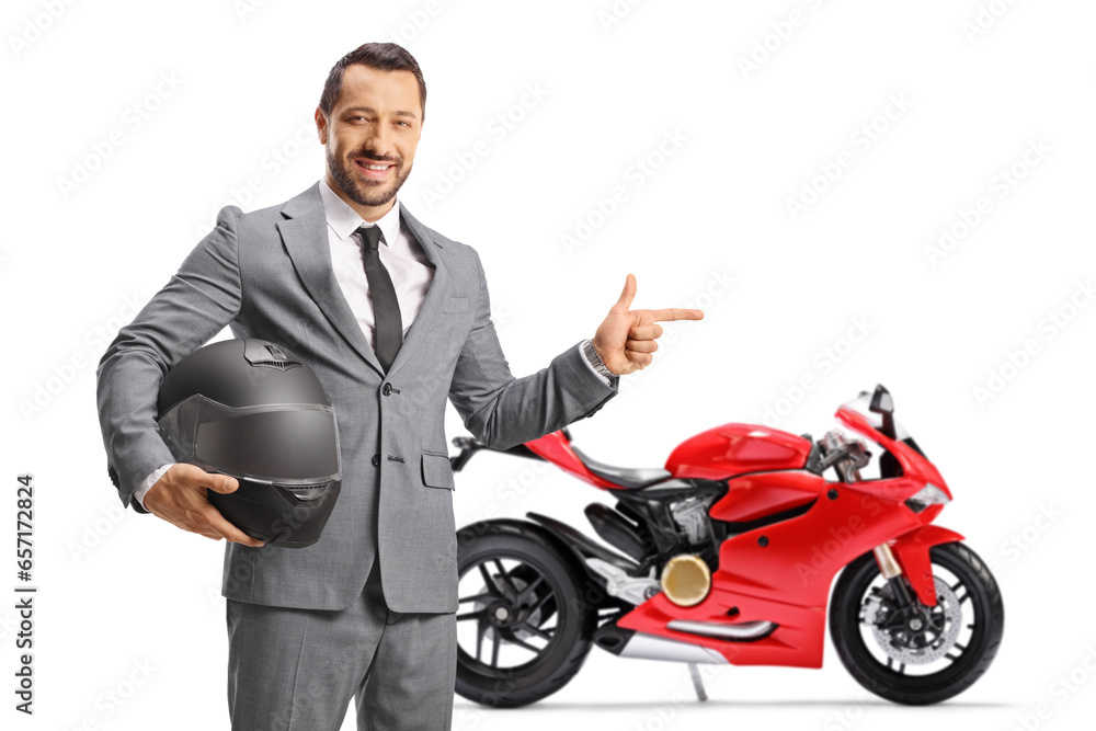 Businessman holding a helmet and pointing at a red motorbike Businessman holding a helmet and pointing at a red motorbike