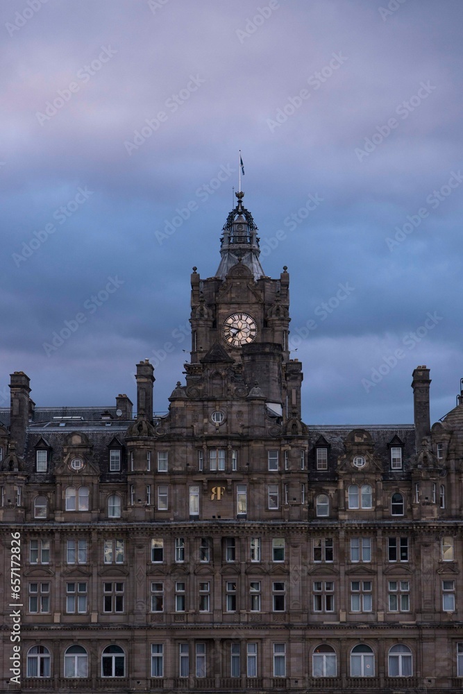 Reloj de edificio de Edinburgo por la noche con cielo azul. 