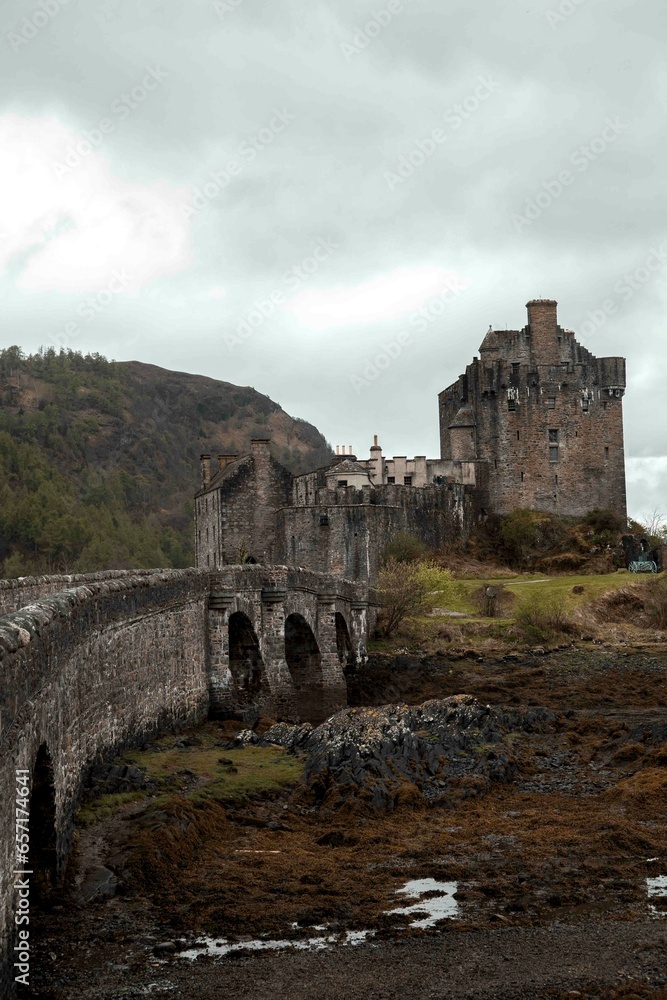 Castillo de Eilean Donan de Escocia con nubes grises y reflejo en el agua. Fondo de castillo escocés. 