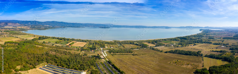 Panoramic aerial view of Lake Trasimeno. Lake Thrasimene is located in the province of Perugia, in the Umbria region of Italy on the border with Tuscany. Around there are cultivated fields.