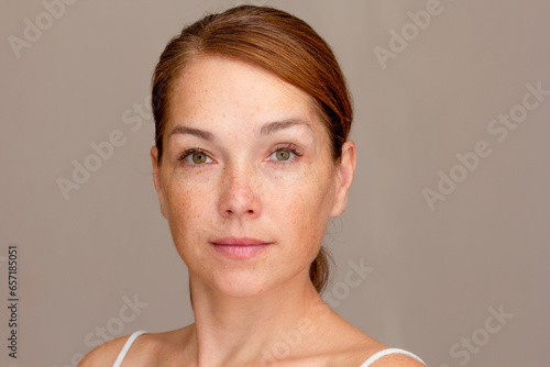 Foto Portrait of caucasian middle aged woman of 40s looking at camera on gray backgro