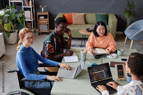 Konstfotografi Portrait of young diverse IT team meeting at table in office and discussing proj