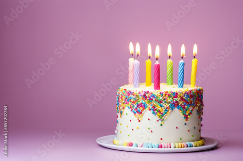 birthday cake with candles decorated with colored sprinkles on a purple background
