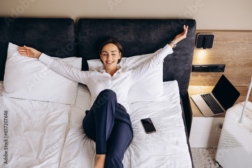Fotografie Business woman lying on a bed in a hotel room