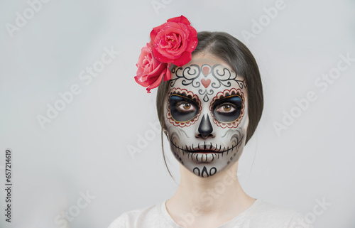 portrait Young woman in day of the dead mask skull face art and rose