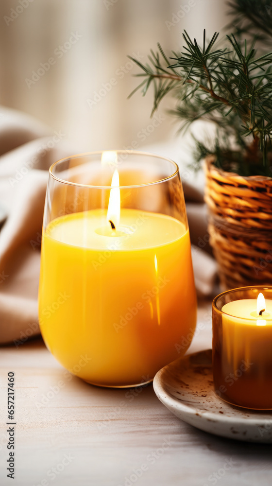 Winter season decoration with green branches. Christmas yellow candle burning and creating cosy atmosphere Winter season decoration with green branches. Christmas yellow candle burning and creating cosy atmosphere