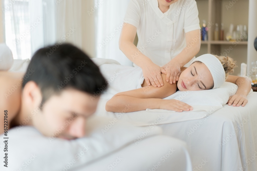 Happy young beautiful couple enjoying back and shoulder massage at the spa. Relaxed Husband And Wife at Asian luxury spa and wellness center - obrazy, fototapety, plakaty 