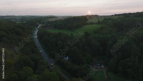 Aerial shot of a busy road through the British countryside at sunrise