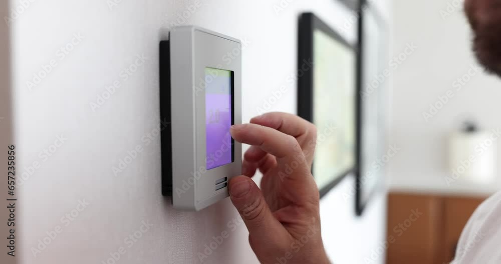 Person changes temperature in big apartment with wall control panel. Homeowner who wants to cool room on hot day slow motion Person changes temperature in big apartment with wall control panel. Homeowner who wants to cool room on hot day slow motion