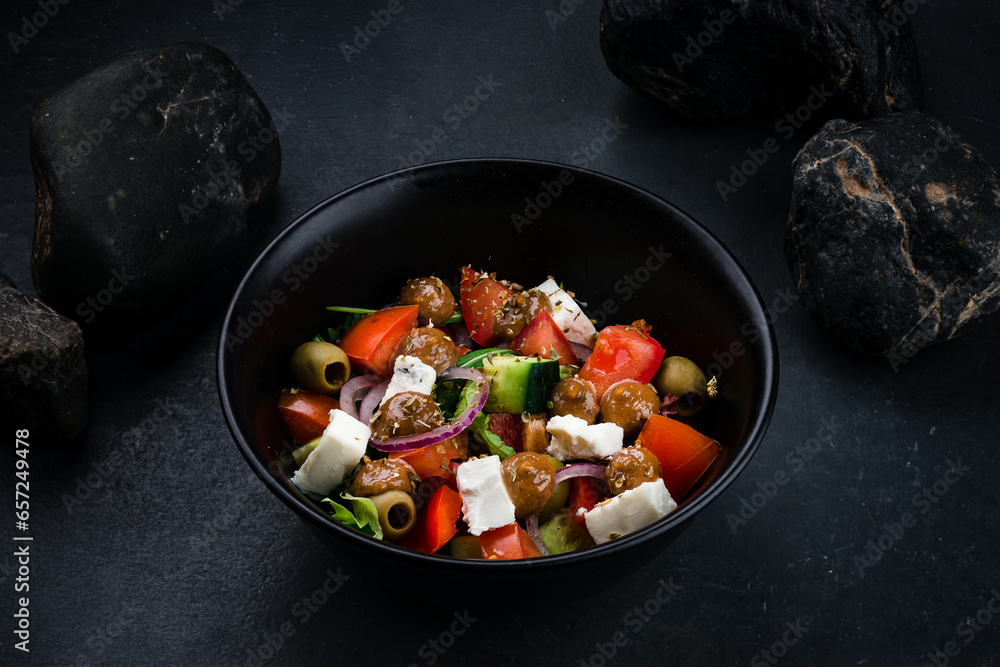 Greek salad of fresh cucumber, tomato, sweet pepper, lettuce, red onion, feta cheese and olives.