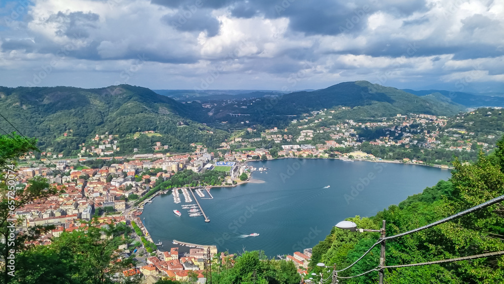 Aerial view of city and lake of Como seen from the funicular in hillside village of Brunate, Lomardy, Italy, Europe. Overcast cloudy day in summer. Living life style, architecture and travel concept