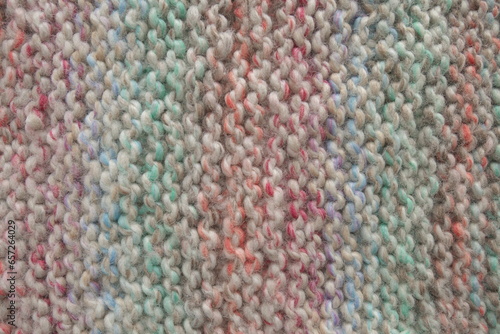 Light pastel colored stripy handmade knitting blanket background.