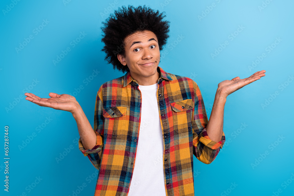 Photo of confused indifferent guy with perming coiffure wear checkered jacket shrugging shoulders isolated on blue color background Photo of confused indifferent guy with perming coiffure wear checkered jacket shrugging shoulders isolated on blue color background