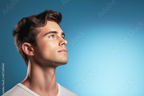 Portrait of young man. Skin care beauty, skincare cosmetics. Isolated over blue background. Copy Space.