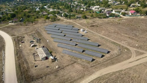 Clean Energy Triumph: A Bird's-Eye View of Solar Panels near a Village. photo