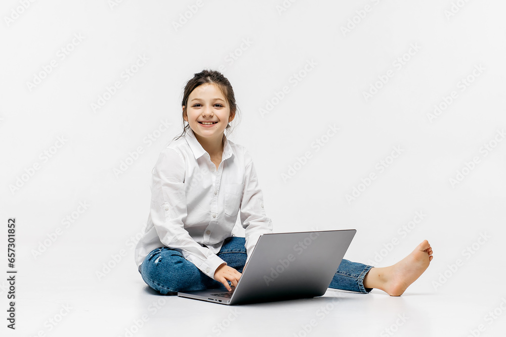 The concept of childish, sincere emotions. A little girl watches a movie on a light background. The concept of advertising a happy childhood and bright emotions with modern technologies. The concept of childish, sincere emotions. A little girl watches a movie on a light background. The concept of advertising a happy childhood and bright emotions with modern technologies.