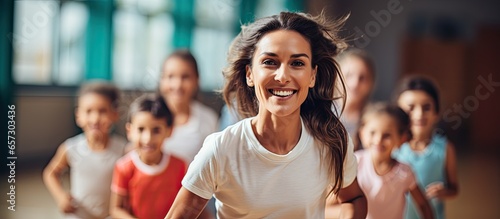 Female gym teacher exercising with students in school gym With copyspace for text photo