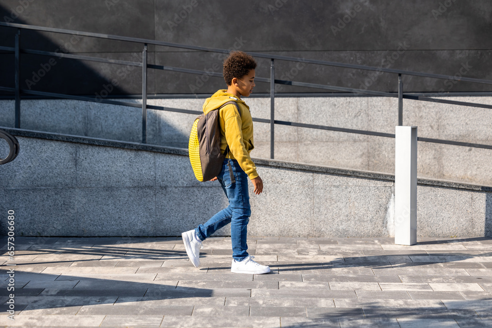 Schoolboy with backpack going home from school Schoolboy with backpack going home from school