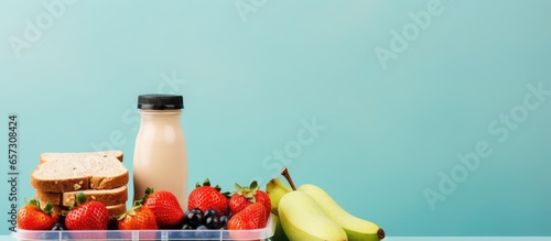 Wholesome lunchbox packed with wholemeal bread milk and fruit With copyspace for text photo