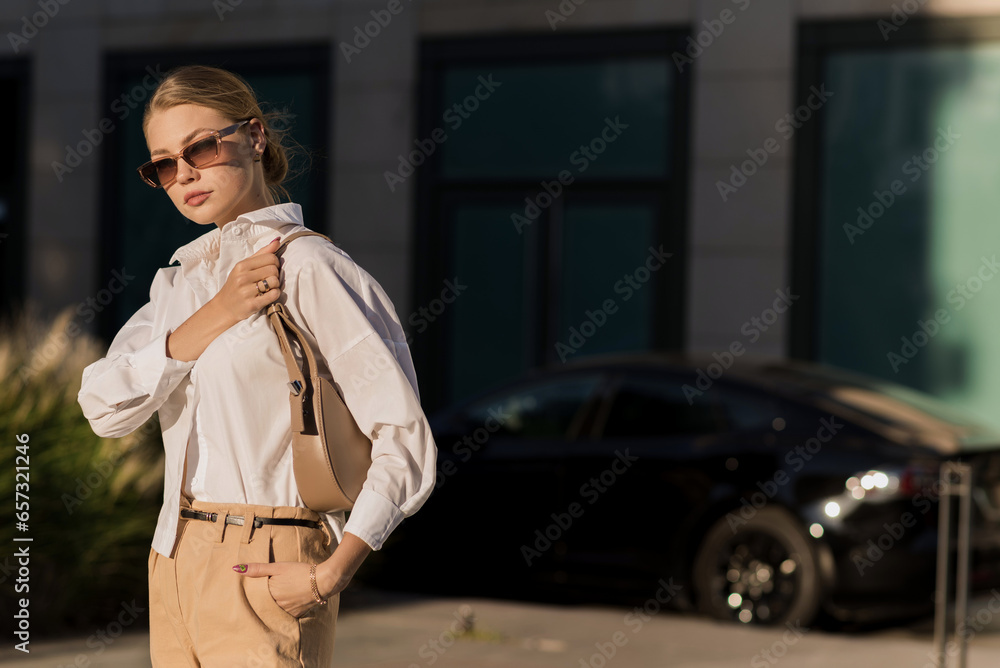 Portrait of a young and attractive Caucasian woman in casual clothes and sunglasses while walking around the city. The concept of fashion, style, youth and lifestyle