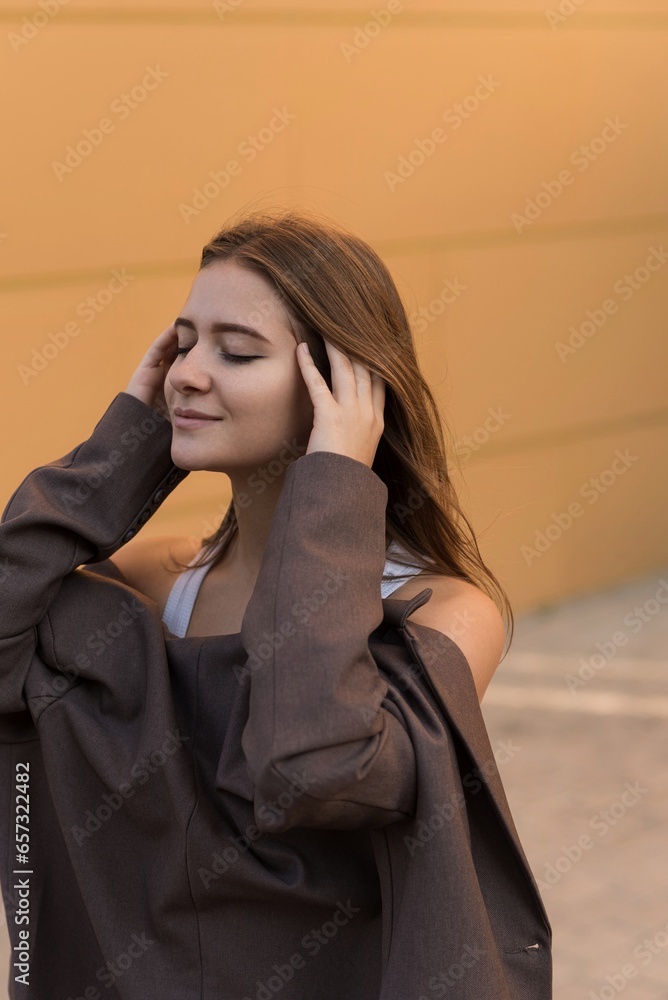 Portrait of a Caucasian attractive and happy young woman in casual clothes in the city while walking on a sunny day. The concept of style, fashion, youth and lifestyle Portrait of a Caucasian attractive and happy young woman in casual clothes in the city while walking on a sunny day. The concept of style, fashion, youth and lifestyle