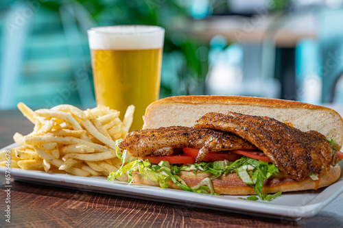 фотографія Blackened Grouper sandwich on a Hoagie Roll with French fries.