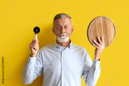 Mature man with pizza cutte...