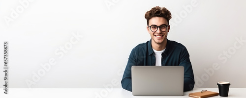 Portrait of a young freelancer man working at a laptop remotely on a white background with copy space. Template banner online training, remote work, courses. 