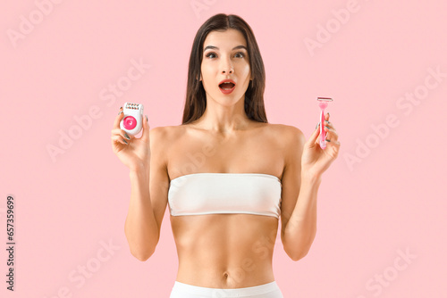 Shocked young woman with epilator and razor on pink background © Pixel-Shot