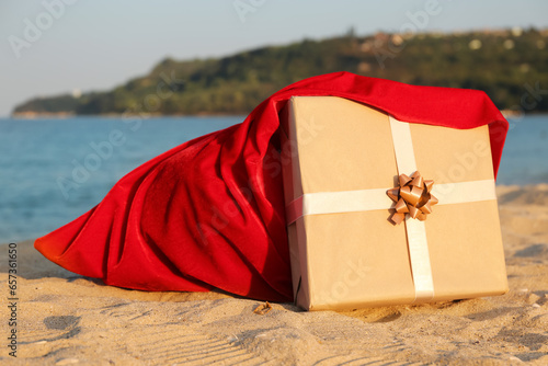 Gift box with Santa bag on sea beach. Christmas vacation concept