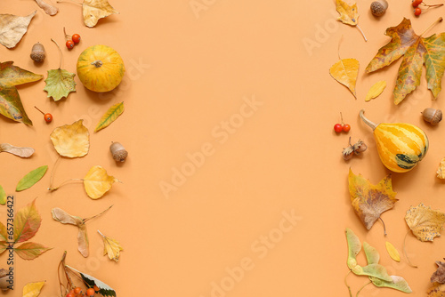 Composition with pumpkins, autumn leaves and acorns on orange background