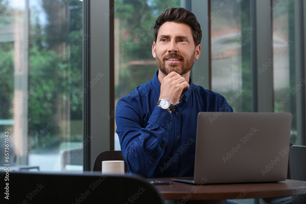 Man with laptop at table in cafe Man with laptop at table in cafe