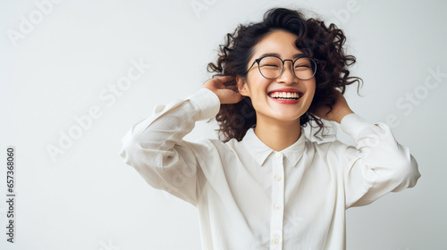 白い室内で眼鏡をかけて微笑む日本人女性