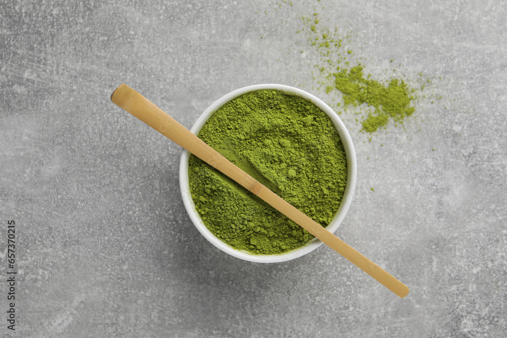 Green matcha powder and bamboo scoop on light grey table, flat lay Green matcha powder and bamboo scoop on light grey table, flat lay