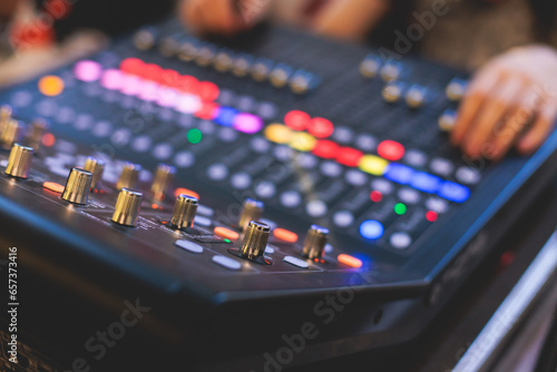 View of lighting technician operator working on mixing console workplace during live event concert on stage show broadcast, light mixer controller panel, sound technician with professional equipment photo