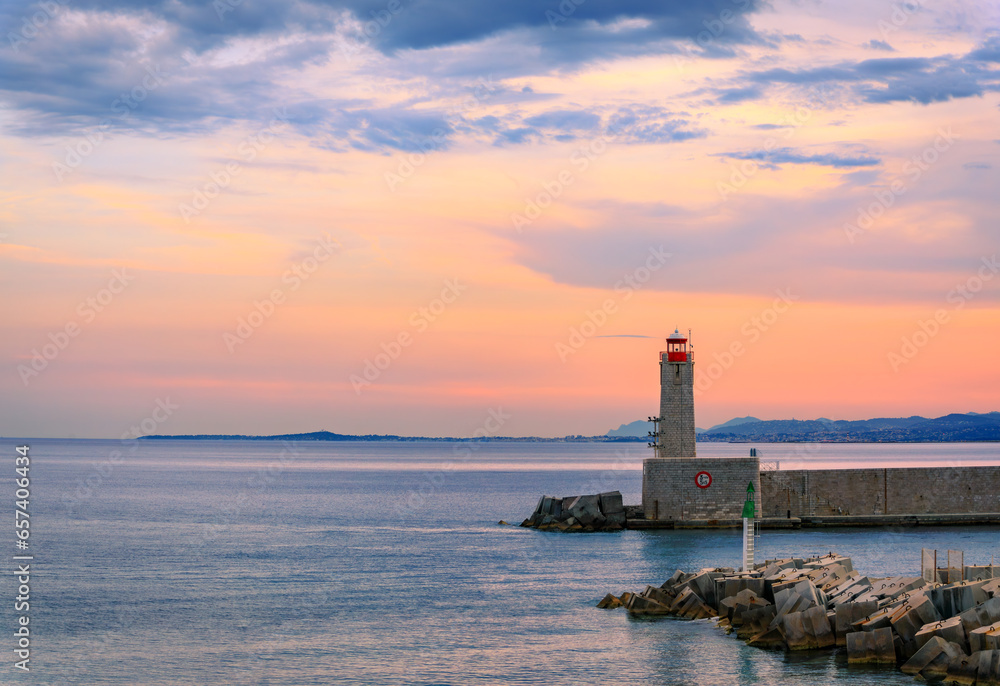 Stunning view of the Mediterranean Sea with the lighthouse in the harbor at sunset in Nice, South of France or the French Riviera