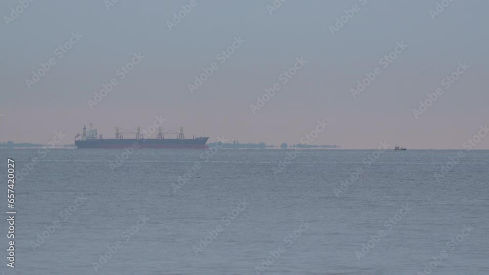 Birds Flying In The Ocean With Cargo Barge Floating In The Background. - wide Birds Flying In The Ocean With Cargo Barge Floating In The Background. - wide
