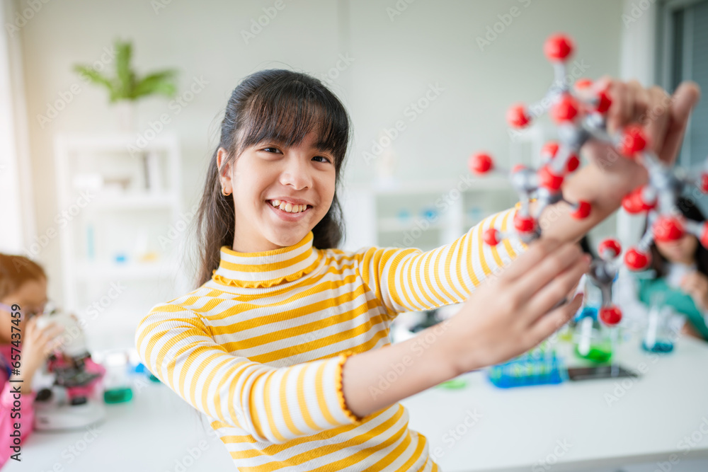 Girl having fun time with holding molecular model learning chemistry science at classroom. Science Laboratory. Girl having fun time with holding molecular model learning chemistry science at classroom. Science Laboratory.