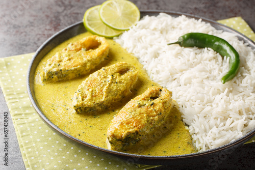 Obraz na płótnie Bengali Shorshe Ilish or Hilsa cooked in Mustard Gravy served with white rice closeup on the plate on the table. Horizontal w salonie